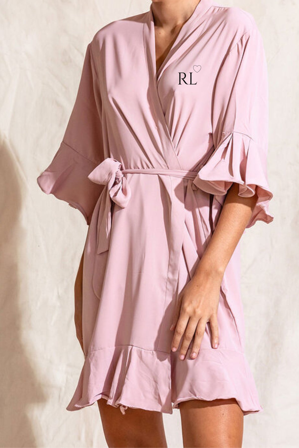 Blush pink crepe satin bridal party robe with ruffle hem and sleeves, front personalised with initials and heart detail