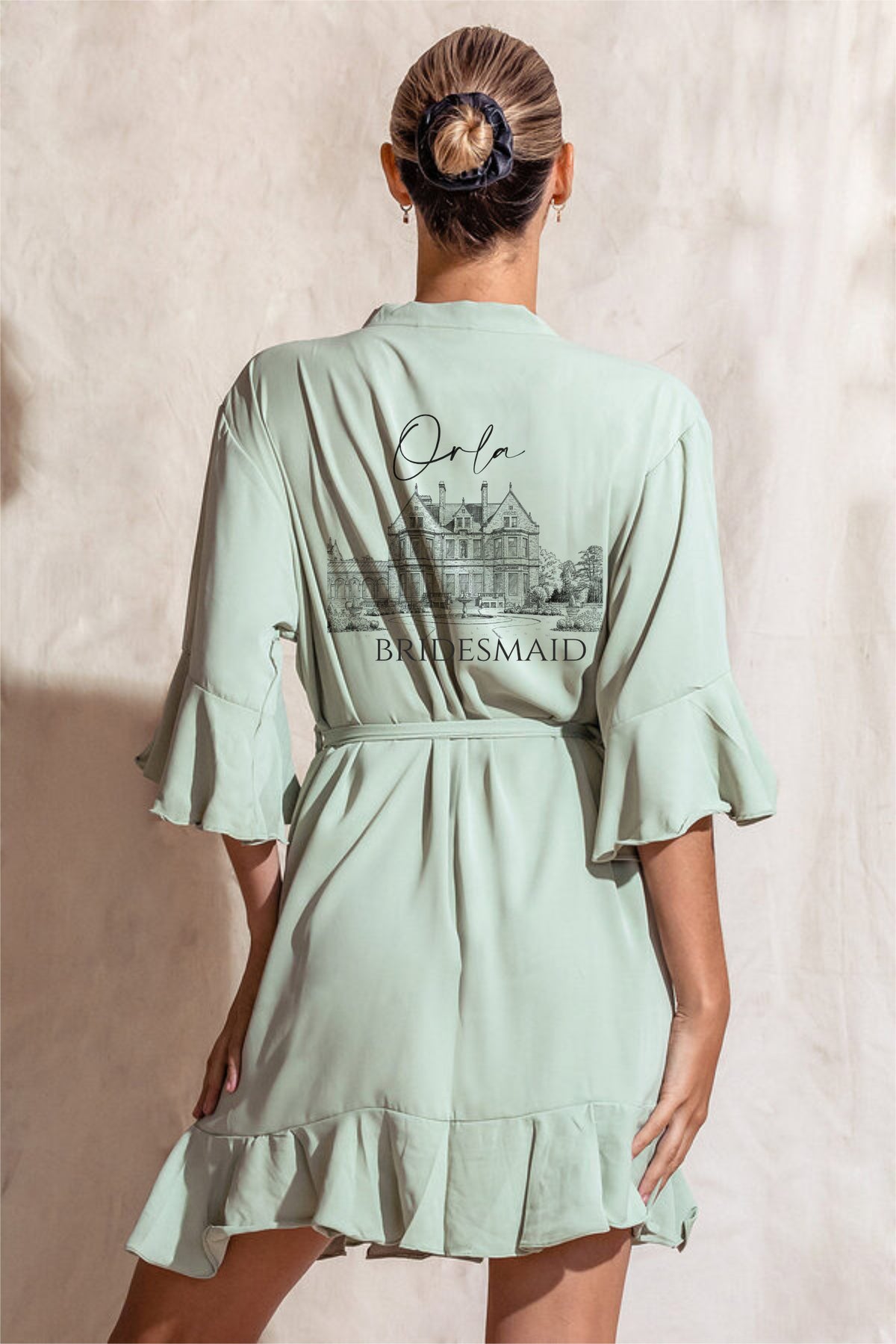 Sage green personalised crepe satin bridal party robe with ruffle hem and sleeves, back personalised with name, role and custom venue illustration